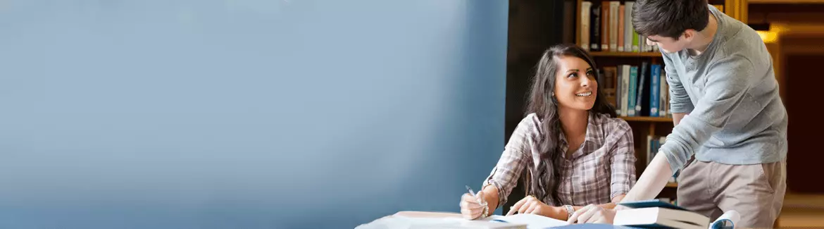 A bright background image of a tutor helping a student at a library